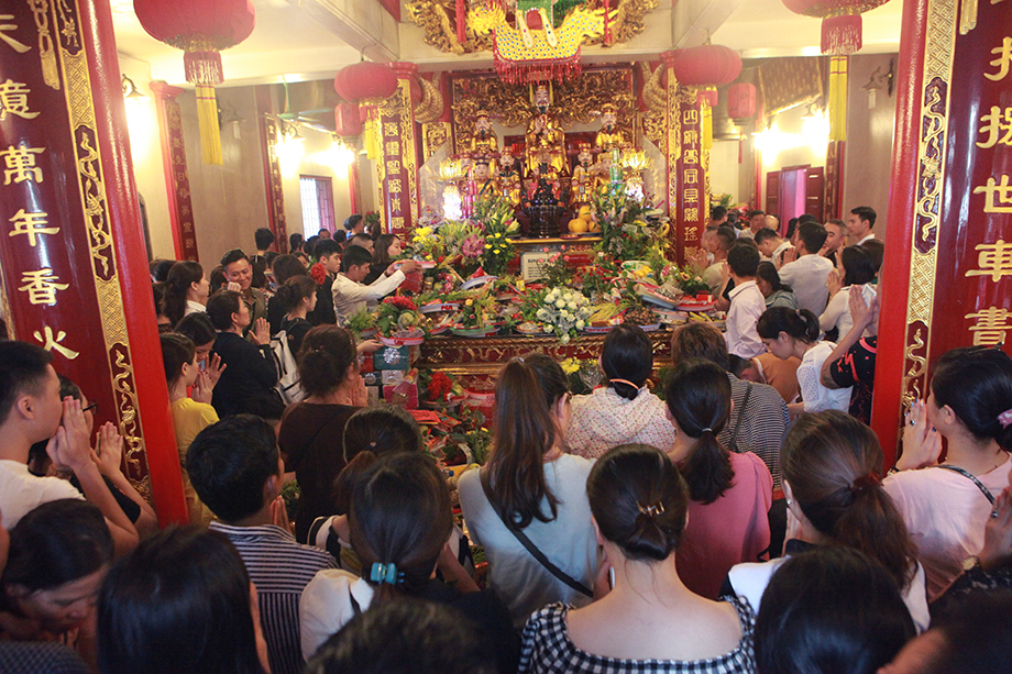 Bên trong Phủ đông nghịt người đứng, ngồi, chắp tay khấn Phật, mâm lễ của người nọ chồng lên người kia