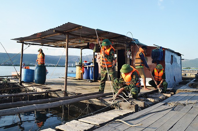 Cán bộ, chiến sĩ Đồn Biên phòng cảng Cẩm Phả hỗ trợ người dân gia cố, chằng buộc lồng bè nuôi trồng thuỷ sản