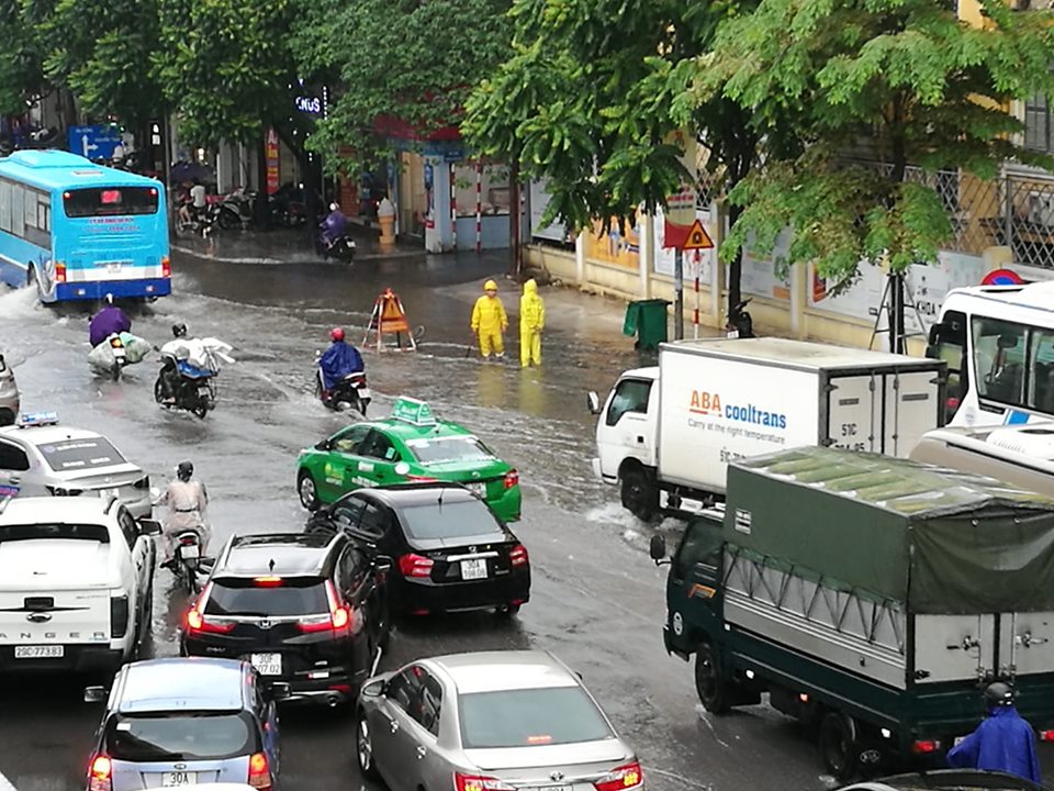 Đường Nguyễn Trãi đoạn qua trường ĐH Khoa học Tự nhiên có một điểm ngập sâu, công nhân thoát nước đang trực để tiêu nước.