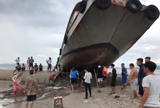 Một chiếc tàu chở khách ở đảo Quan Lạn, Vân Đồn (Quảng Ninh) bị mắc kẹt, nằm "vắt vẻo" trên đê bao lấn biển khi đang trên đường về nơi tránh trú bão số 3.