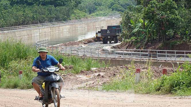 Người dân đang đi qua khu vực thi công này bằng một đường tránh tạm gồ ghề và nhếch nhạc.