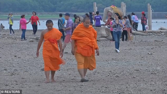 Nhiều nhà sư, du khách tới thăm phần còn lại của ngôi chùa từng bị ngập sâu trong nước