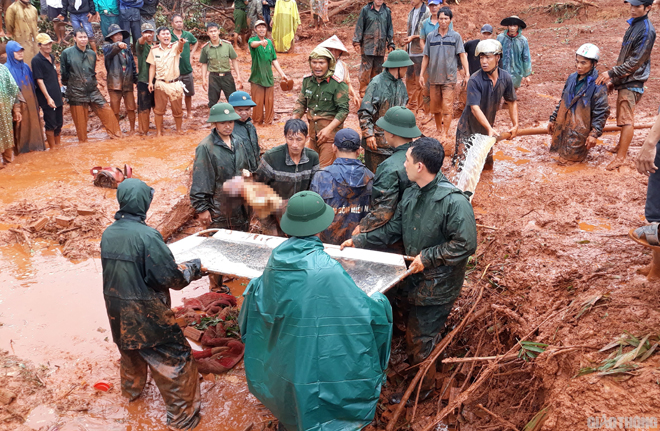 Giây phút đầu tiên tìm thấy cháu bé Diệu trong đóng bùn đất. Ảnh: Ngọc Hùng.