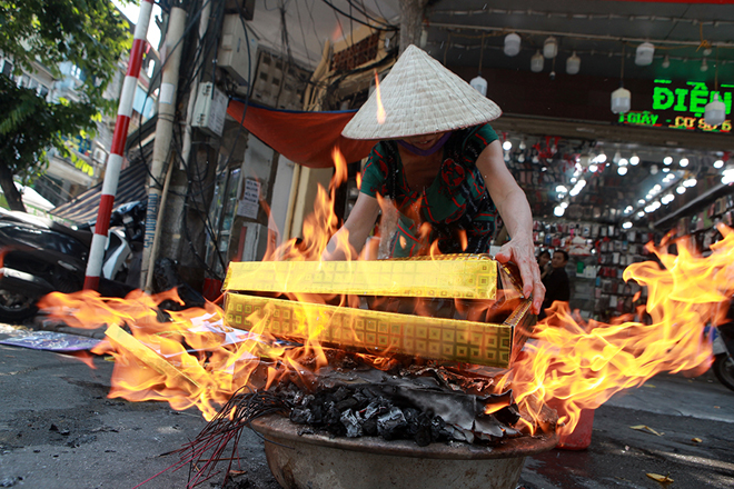 Một hộ gia đình đốt vàng mã ở&nbsp;góc phố gần chợ Đồng Xuân.