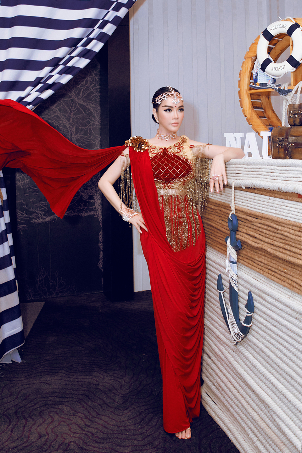 Chiếc đầm haute couture màu đỏ đậm được đo may riêng cho Lý Nhã Kỳ.&nbsp;NTK Ấn Độ đã khéo léo may những đường chỉ vàng tua rua, cộng với vàng lá lấp lánh đính trên vai. Trang phục được hoàn thành sau hơn&nbsp;4 tháng.