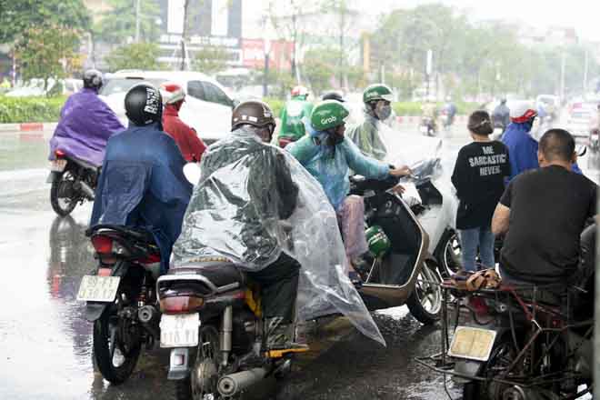 Mưa lớn khiến&nbsp;nhiều người đi xe máy phải dừng&nbsp;lại để đảm bảo an toàn