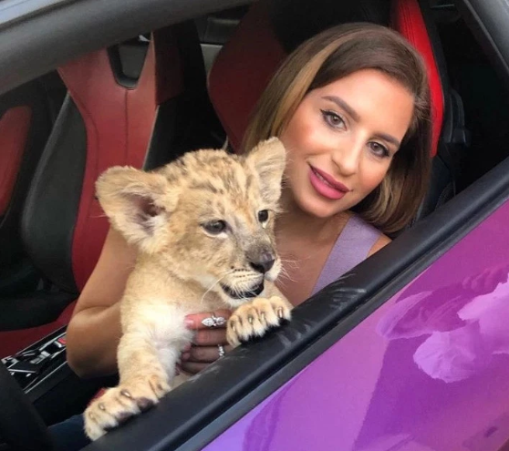 Natalia chụp cùng chú sư tử con trong chiếc Lamborghini màu tím.