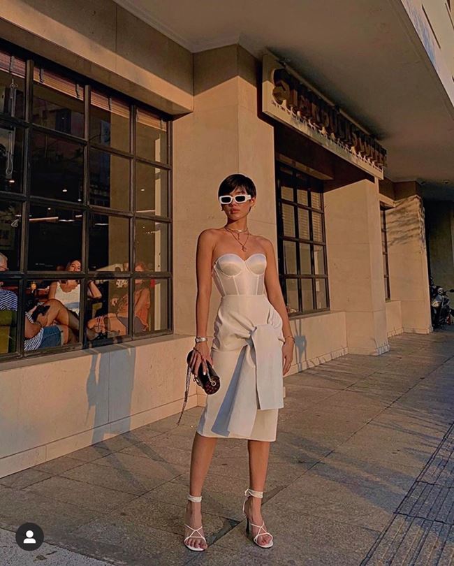 Khác với Chi Pu và Đông Nhi, Khánh Linh chọn cách lên đồ theo all white với chân váy và giày cao  gót màu trắng, điểm nhấn từ túi xách cầm tay. 