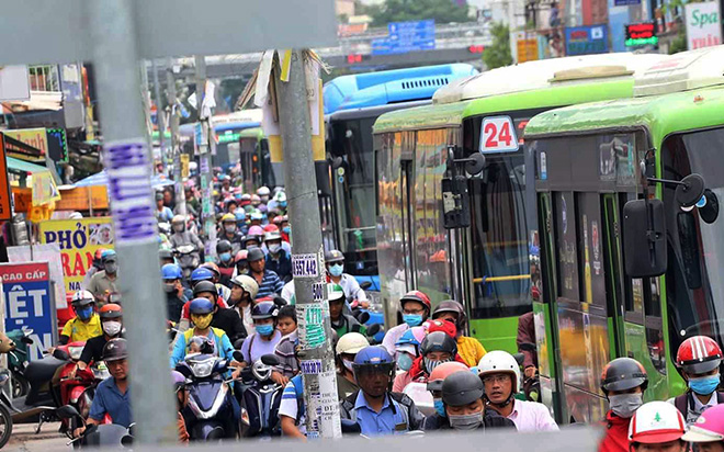 Mọi chỗ trống trên vỉa hè đều bị người đi xe máy chạy lên để cố tìm đường thoát khỏi kẹt xe. Để di chuyển đoạn đường hơn 1km ra tới bến xe Miền Đông nhiều người phải mất gần 1 giờ.