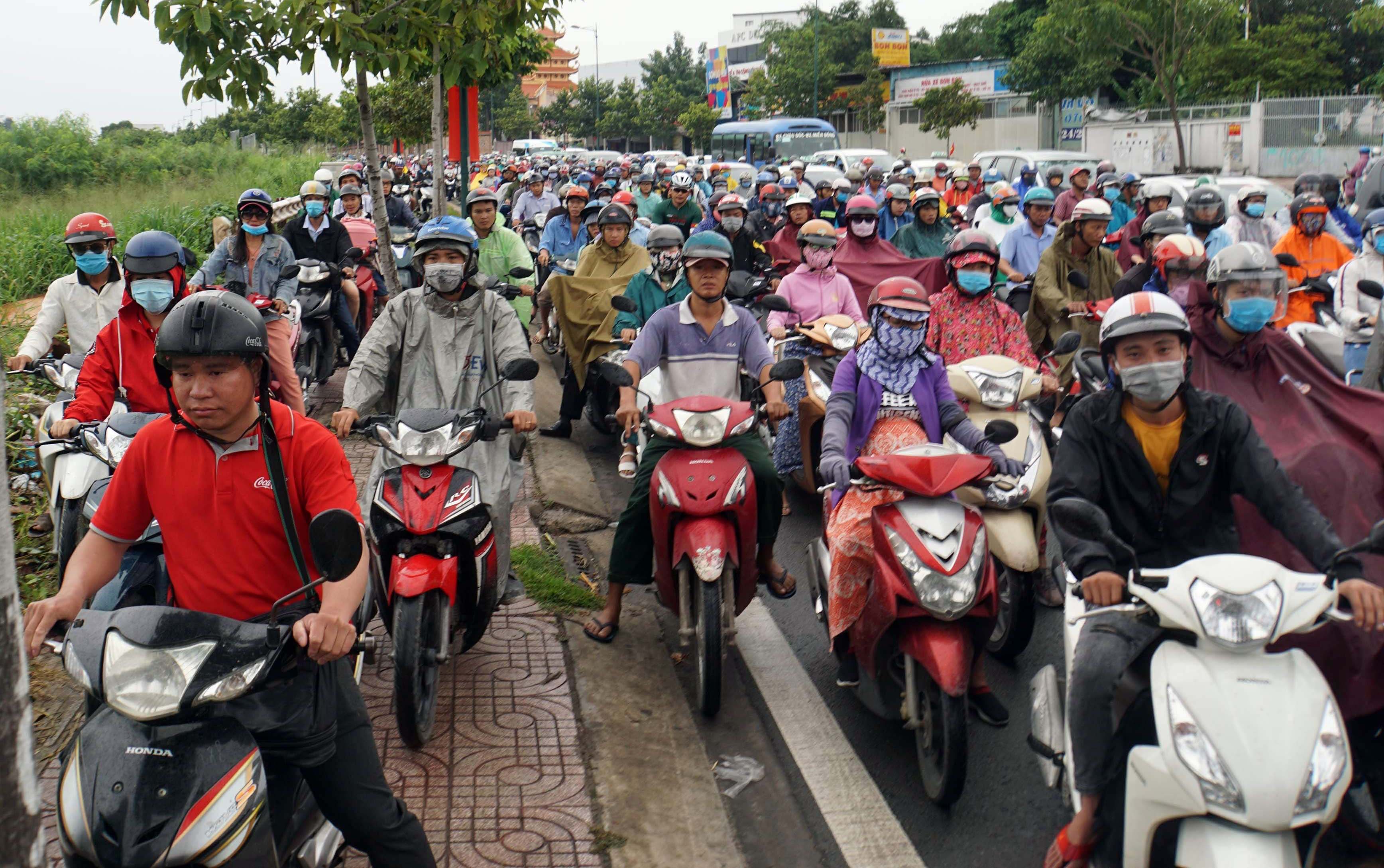 Một số người chạy xe lên vỉa hè để tránh kẹt xe nhưng vẫn không thoát. “Kẹt xe tứ bề, đi đường nào cũng kẹt nên phải đứng đây chịu trận”, anh Phan Văn Hoàng ngụ quận Thủ Đức nói.