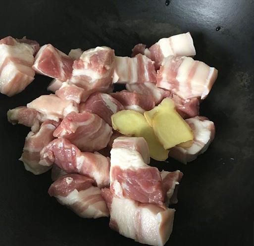 Thịt heo cắt thành miếng vuông 2cm, thêm thịt và gừng cắt lát mỏng vào nồi.