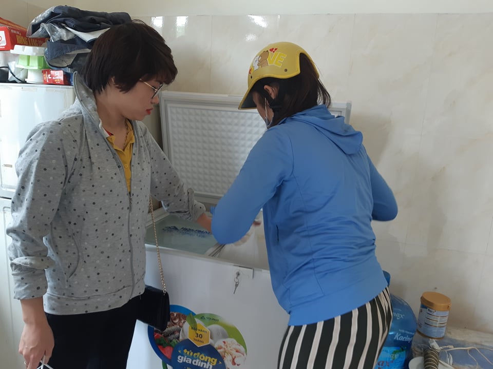 Chị Liên và chị Linh xếp các bịch sữa ngay ngắn vào tủ cấp đông của gia đình.