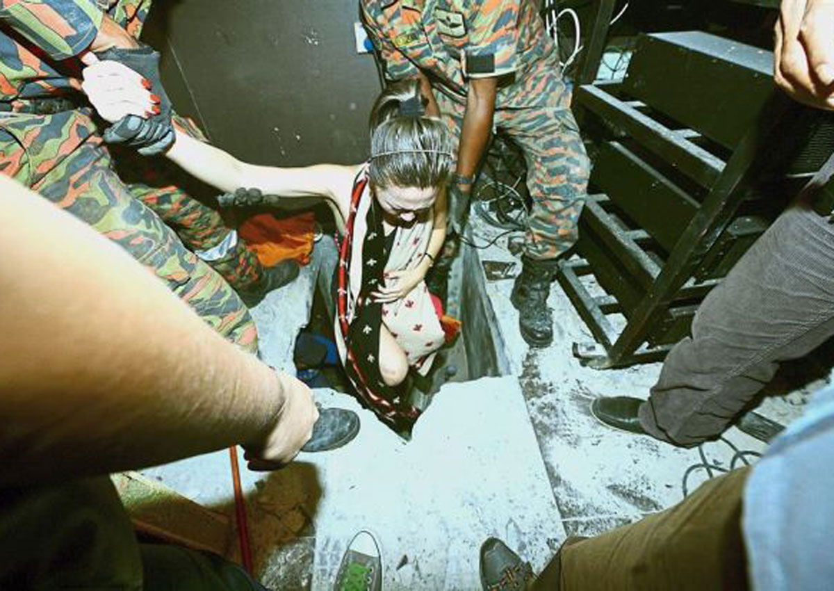 Cảnh sát đưa một cô gái ra khỏi căn hầm được xây dựng hiện đại và trang bị hệ thống khóa thủy lực.