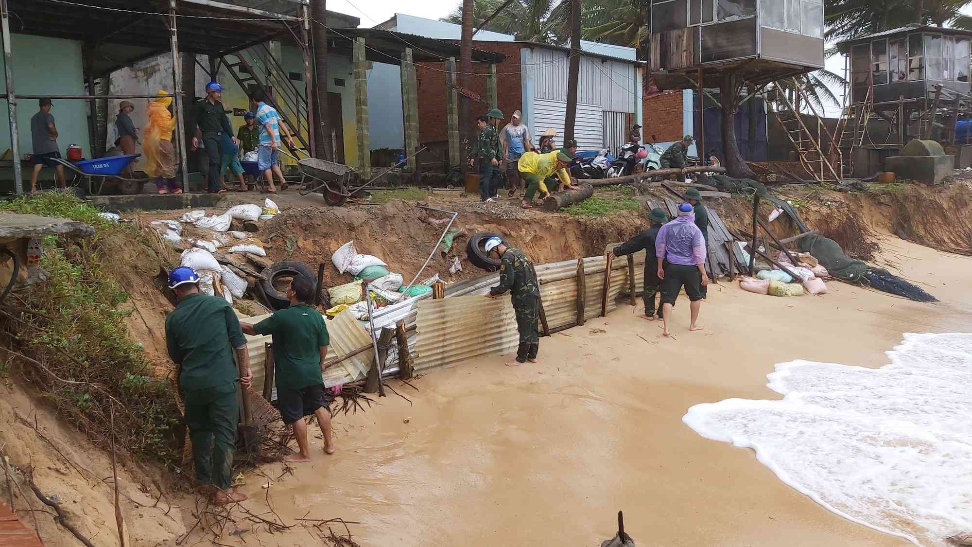 Lực lượng quân đội và công an đang giúp dân che chắn để ngăn sạt lở