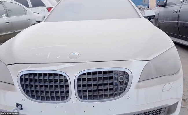 Logo của một chiếc BMW hầu như không thể nhận ra trên nắp ca-pô do phủ đầy bụi. Chiếc xe này nằm tại một trong những bãi xe lớn nhất trong khu vực. Khách du lịch thường đến đây để mua các bộ phận tháo rời.
