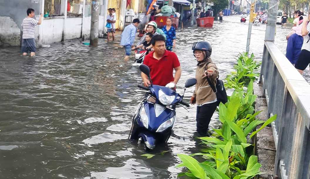 Nhiều đoạn nước ngập lút bánh xe máy khiến hàng loạt xe bị chết máy. “Đến chỗ làm mà gặp cảnh nước ngập này như cực hình vậy. Mệt không thể diễn tả nổi, quần áo, giày bị ướt thế này nên sáng nay tôi xin đến công ty trễ”, chị Phạm Thị Ngân, người dân đường Mễ Cốc nói. (Ảnh: P.T.L.)