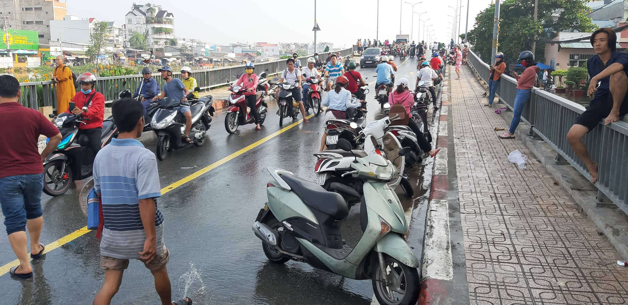 Người dân tập trung khu vực cầu Kênh Ngang số 3 để chờ nước rút. Đến 9h30 cùng ngày, khu vực này vẫn còn ngập như sông. (ảnh: P.T.L.)