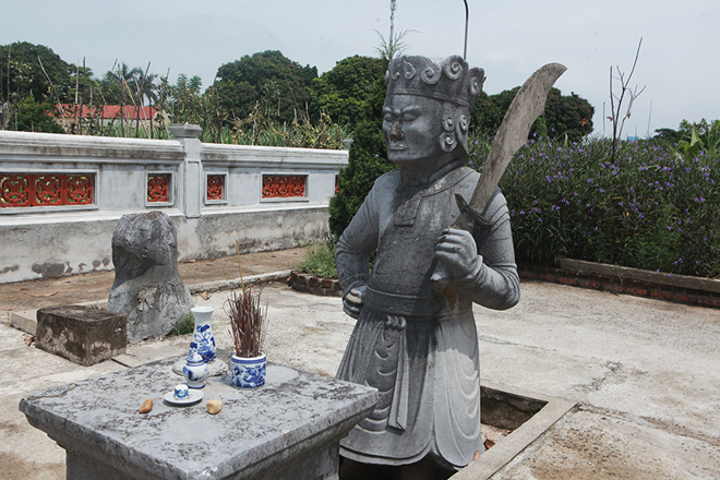 Bước qua cánh cổng là hình ảnh tượng đá ngồi canh cửa ở cổng lăng. Hai pho tượng cầm đao tượng trưng cho những người lính tráng bảo vệ cho cung điện vua chúa ngày xưa