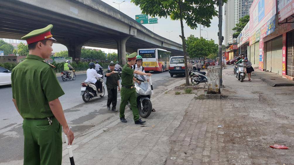 Đội CSGT trật tự Công an quận Thanh Xuân, TP Hà Nội lập biên bản xử lý người đi trên vỉa hè ngược chiều đường Nguyễn Xiển