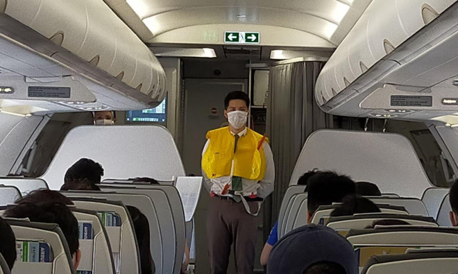Tiếp viên hướng dẫn sử dụng áo phao trên máy bay