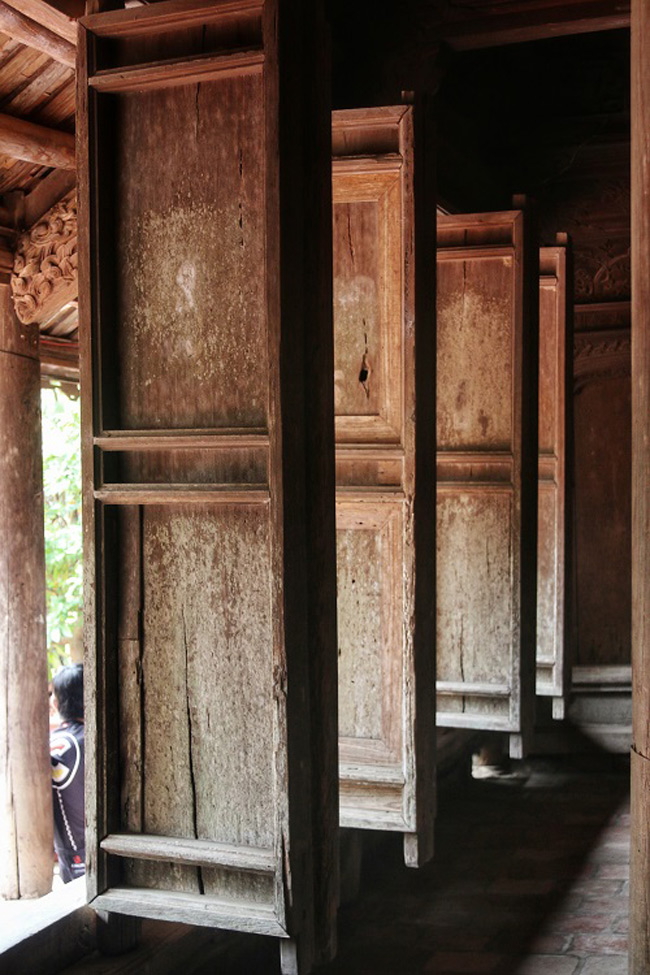 Cửa bức bàn truyền thống với 6 cánh chính, được lắp giữa các cột đan xen, cánh cửa có thể tháo rời.
