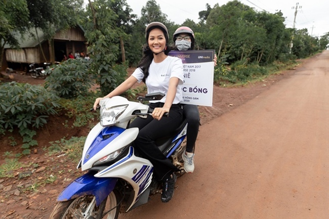Hoa hậu H'Hen Niê đi xe máy làm từ thiện.
