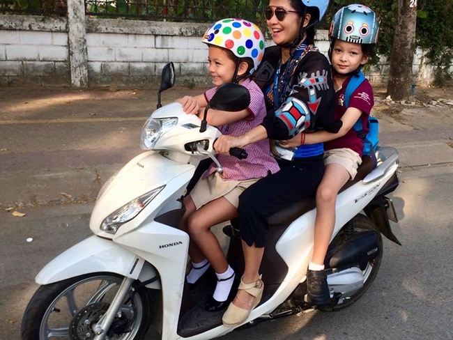 Thời điểm mới ly hôn chồng Tây, diva Hồng Nhung tự lái xe máy chở hai con đi học.
