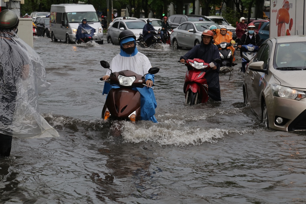 Đoạn gần chân cầu vượt Nguyễn Hữu Cảnh bị ngập sâu, gần lút bánh xe máy khiến người dân phải “bơi” về nhà.