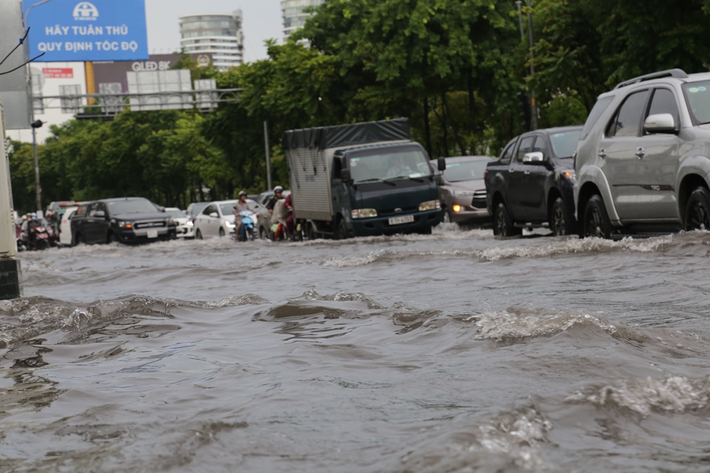 Sóng nước cuồn cuộn trên đường mỗi khi có xe ô tô chạy qua.