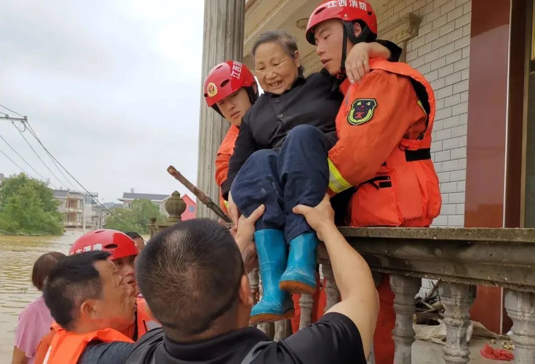 Lính cứu hỏa giải cứu một cụ bà khỏi nhà (ảnh: Xinhua)