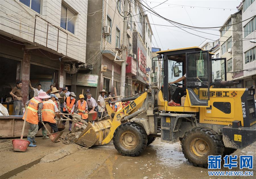 Máy xúc dọn bùn đất trên phố ở Phiên Dương (ảnh: Xinhua)