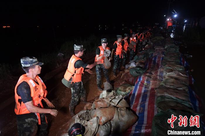 Sĩ quan và quân nhân của lực lượng cơ động, thuộc quân đoàn Giang Tây, đang di chuyển các bao cát dọc tuyến đầu kiểm soát lũ lụt tại huyện Phiên Dương, tỉnh Giang Tây, Trung Quốc, hôm 11/7.&nbsp;Ảnh: China News