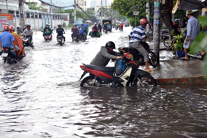 Nhiều người xe bị chết máy phải hì hục dẫn bộ và “bơi” cả km trên đường Phan Anh.