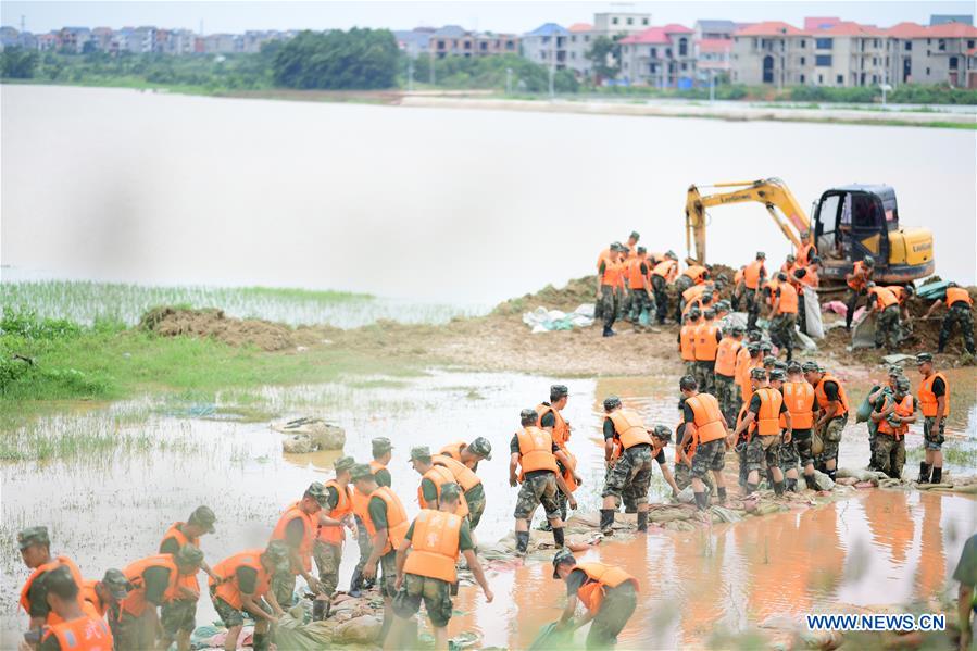 Binh sĩ, cảnh sát và người dân chuyển cát vá đê ở Giang Tây (ảnh: Xinhua)