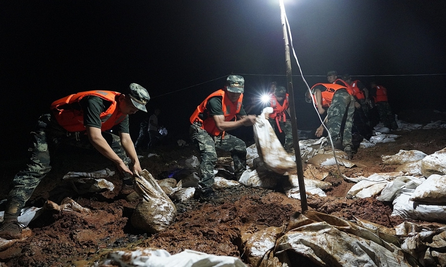 Binh sĩ Trung Quốc làm việc suốt đêm để vá đê (ảnh: Xinhua)