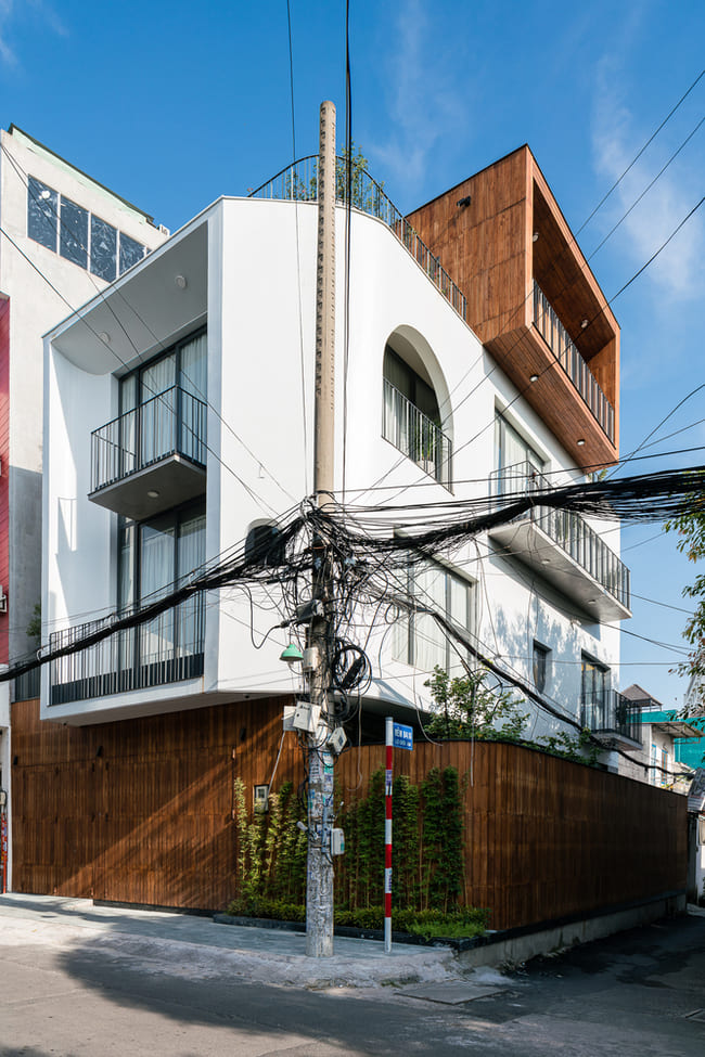 Nằm ở ngã ba của một con hẻm ở Sài Gòn, ngôi nhà có một lớp hàng rào dày để ngăn tiếng ồn không mong muốn từ những con phố đông đúc, và tường gỗ để che giấu khéo léo hệ thống cửa.
