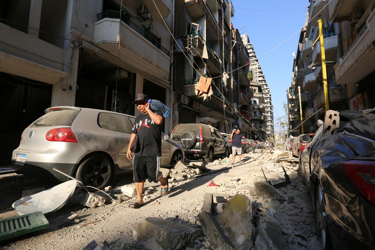 Người dân tại&nbsp;Beirut đi nhận thực phẩm và nước uống sau vụ nổ kinh hoàng (ảnh: Reuters)