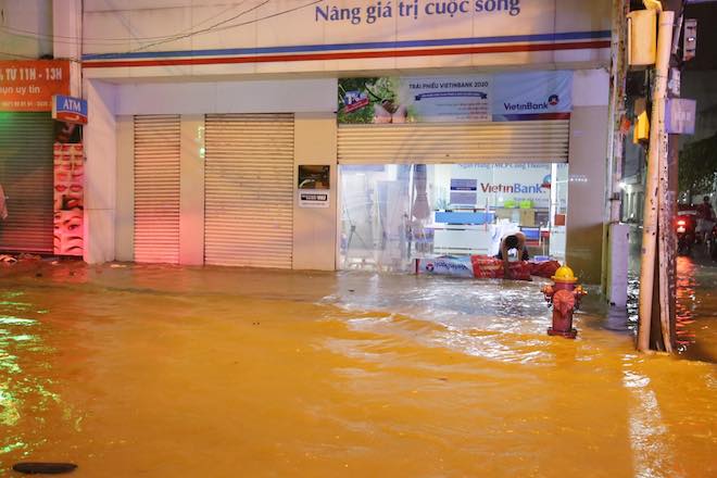 Nước tràn vào khiến một chi nhánh ngân hàng phải dùng mọi biện pháp che chắn khoảng hở.