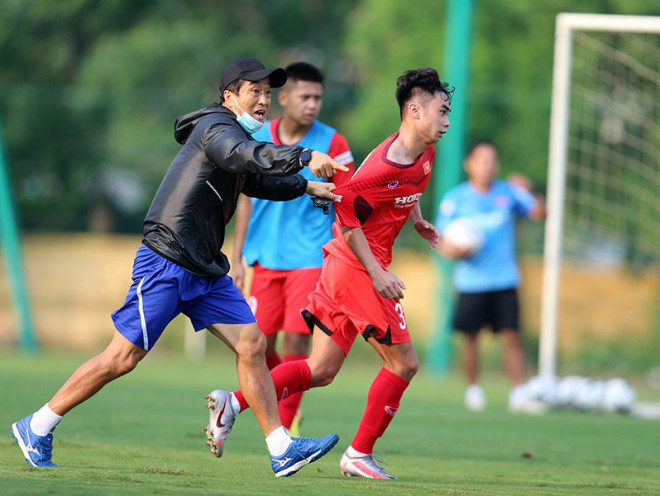 Bên đây sân, thầy Park sửa từng động tác chân cho học trò… Bên kia sân, trợ lý Lee Young-jin dạy cầu thủ thoát truy cản và tiểu xảo. Ảnh: NGỌC DUNG