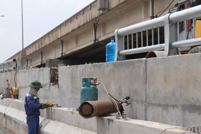 Công nhân khẩn trương thi công hạng mục lan can trên tuyến đường dẫn từ cầu vượt thấp lên đường trên Vành đai 3 trên cao