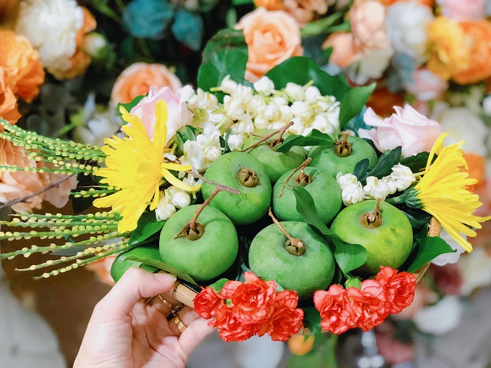 Mẹt hoa quả trị giá 150.000 đồng với quả thị, hoa nhài, hoa hồng, hoa cúc, hoa cẩm chướng và hoa cau - Ảnh: Hà Phương Mai.
