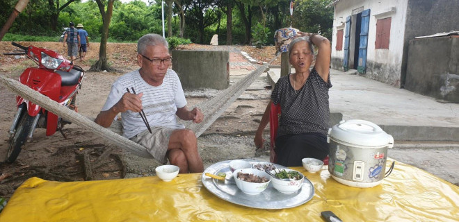 Bữa cơm trưa dưới tán cây chõi của hai vợ chồng ngư dân thôn Nam Đồng.