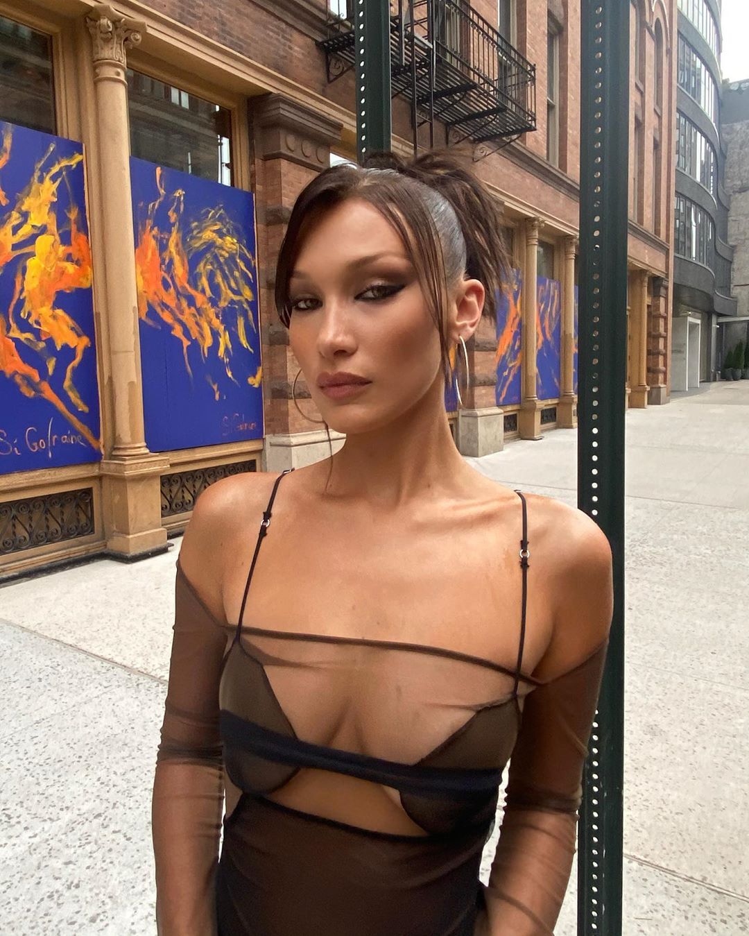 Bella Hadid xuống phố trong bộ đồ xuyên thấu, ép vòng một bằng thiết kế đai ngang mới mẻ. Cô cũng không ngần ngại để lộ dây quai áo thậm chí là dây quần nhỏ khi kết hợp với chiếc quần ngắn hở rốn cùng tone màu.