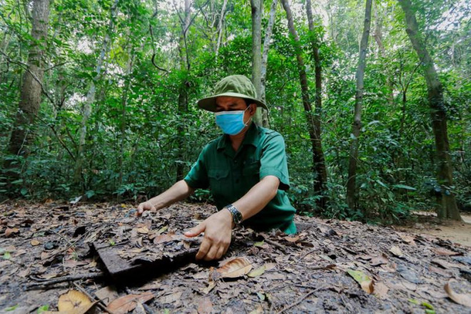 Anh La Văn Hoạch (hướng dẫn viên) mô phỏng cách chui qua cửa hầm dẫn vào địa đạo. Cửa hầm được thiết kế vừa với thân hình bộ đội Việt Nam, cửa được ngụy trang trên mặt đất rất kỹ.&nbsp;