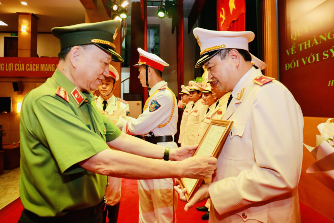 Thừa ủy quyền của Chủ tịch nước, Đại tướng Tô Lâm, Ủy viên Bộ Chính Trị, Bộ trưởng Bộ Công an, trao quyết định thăng cấp bậc hàm thiếu tướng cho ông Trần Phú Hà
