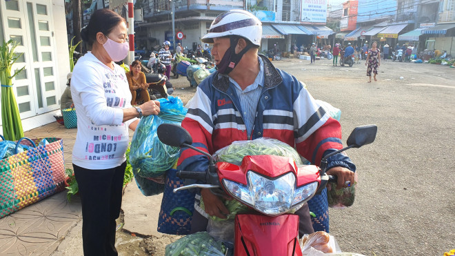 Tiểu thương chợ Tân An đưa rau, củ cho ông Trần Quốc Việt để giao đến các chùa nấu những bữa cơm từ thiện giúp người nghèo