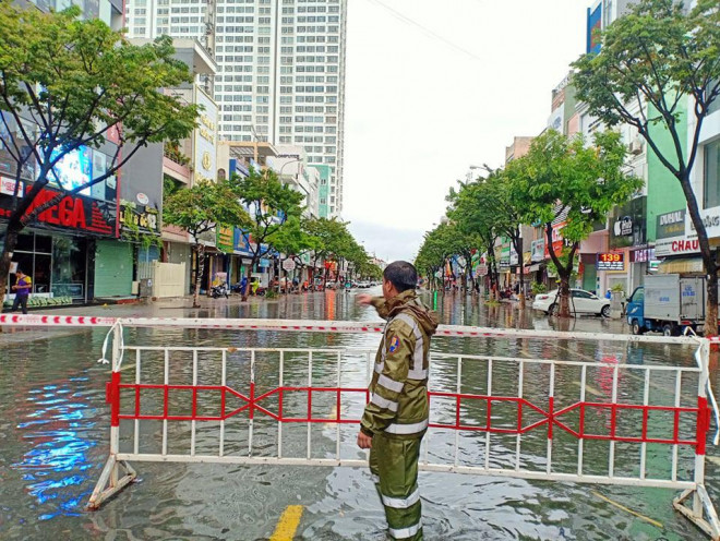 Lực lượng cảnh sát lập rào chắn, hạn chế người dân ra vào khu vực ngập úng tại tuyến đường Hàm Nghi.