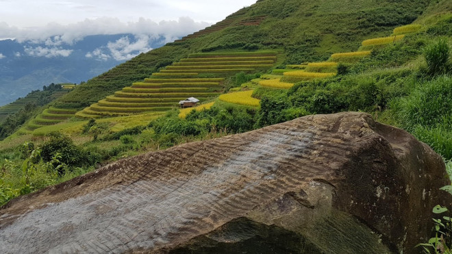 Sự tương đồng của hình ruộng bậc thang trong hình vẽ với thực tế trên ngọn núi phía sau. Ảnh Xuân Ba.&nbsp;