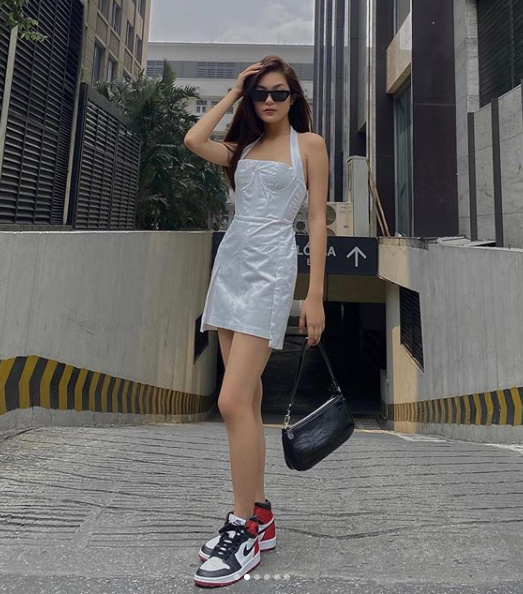 Street style của Linh Chi bao gồm một chiếc váy ngắn, kết hợp cùng sneaker và túi xách, đơn giản mà cực kì sành điệu.