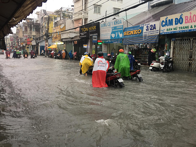 Người dân “bơi” trên đường khi đi qua khu vực chợ Thủ Đức. Khu vực này nước chảy xiết sau mưa nên nhiều người đi xe máy phải gồng mình để không bị ngã. Một số đoạn nước chảy mạnh cuốn trôi cả người và xe máy.